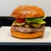 Hamburguesa casera gourmet con pan artesanal hecho en panificadora Silvercrest, servida en un plato blanco.