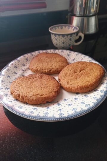 Galletas speculoos caseras en panificadora sobre plato decorado, crujientes y doradas.