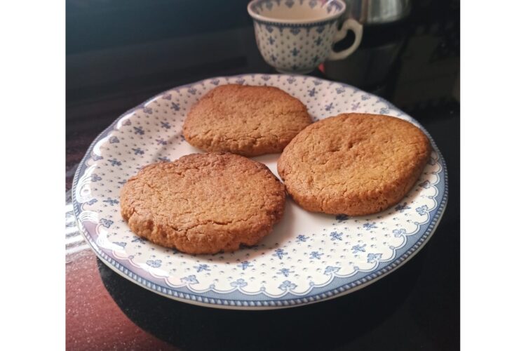 Galletas speculoos caseras en panificadora sobre plato decorado, crujientes y doradas.