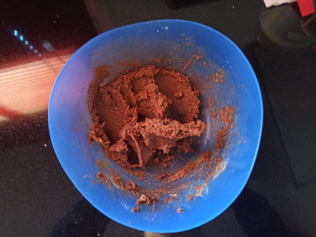 Relleno de cacao, pistacho y mantequilla recién mezclado en un bol, listo para untar sobre la masa.